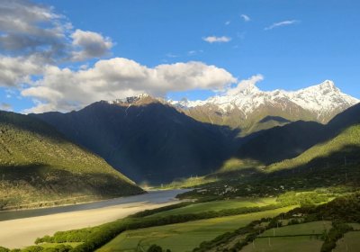 Traveler photo: In early summer, Tibet's snow-capped peaks still stand as green slopes awaken below—full of life. (June 2026)
