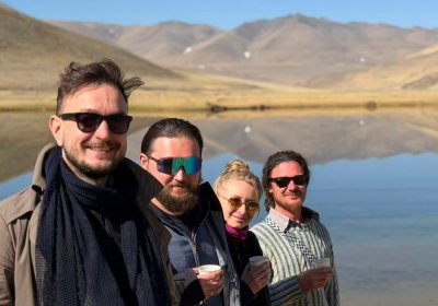 Traveler photo: Friends crowd into the frame, using the holy lake as backdrop for a natural, candid selfie. (May 2026)