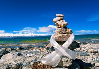Traveler photo: Mani stone piles along the shore of Lake Namtso, surrounded by the white Hada and symbolizing the blessings. (May 2026)	