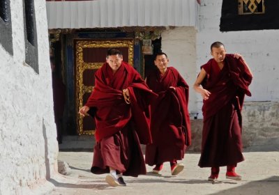 Traveler photo: Candid shot: red-robed monks striding through a Lhasa alley, focused as if rushing to their next practice. (May 2026)