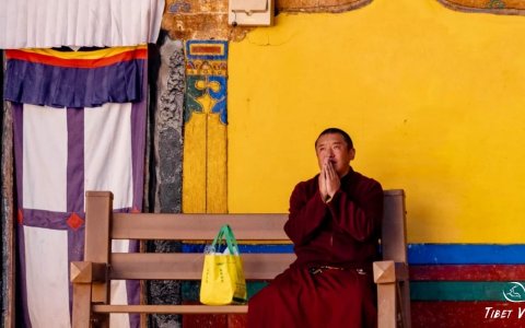 Traveler photo: A Tibetan monk in red robes praying.(May 2025)