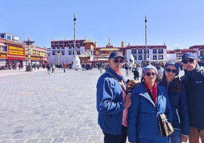 Traveler photo: Before traditional architecture on Barkhor Street in Lhasa, a happy family documents their Tibet journey. (November 2025)