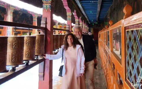 Traveler photo: Our beloved guests are spinning the large prayer wheel outside a Tibetan monastery. (September 2025)
