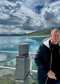 Traveler photo: Our traveler strolls along Yamdrok Lake, one of the three holy lakes in Tibet. (September 2026)