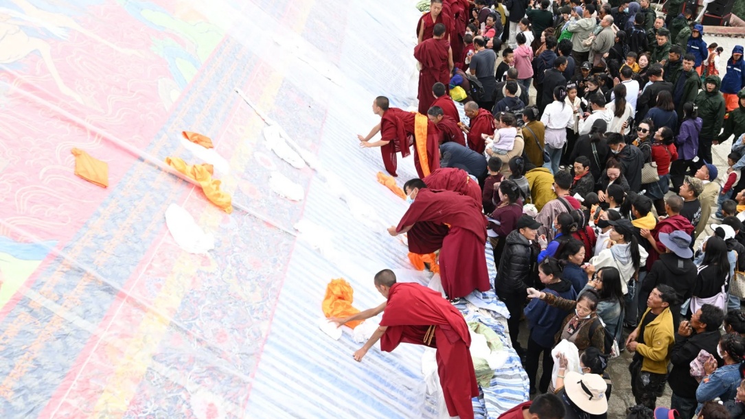 Tibetan monks presenting giant Thangka banner