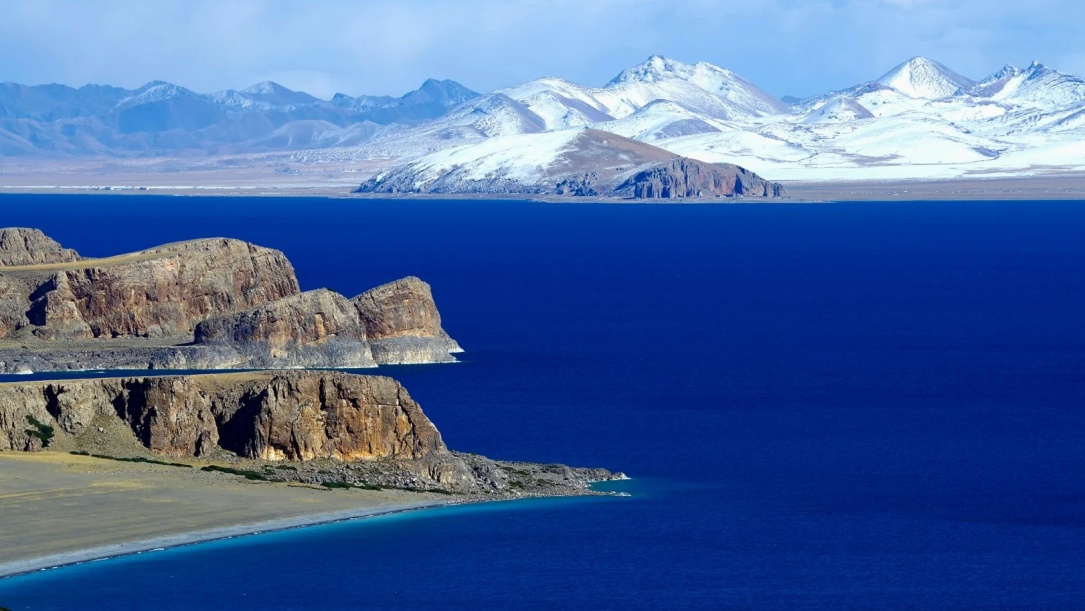 Deep blue holy Namtso Lake and snow mountains
