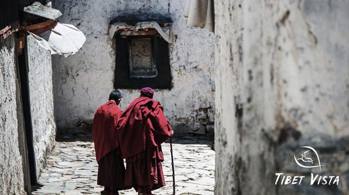 Capture whitewashed walls of Drepung Monastery and monks wearing red robes