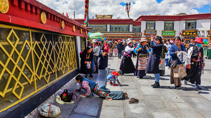 Tibetan pilgrim performing full-body prostrations around Jokhang Temple