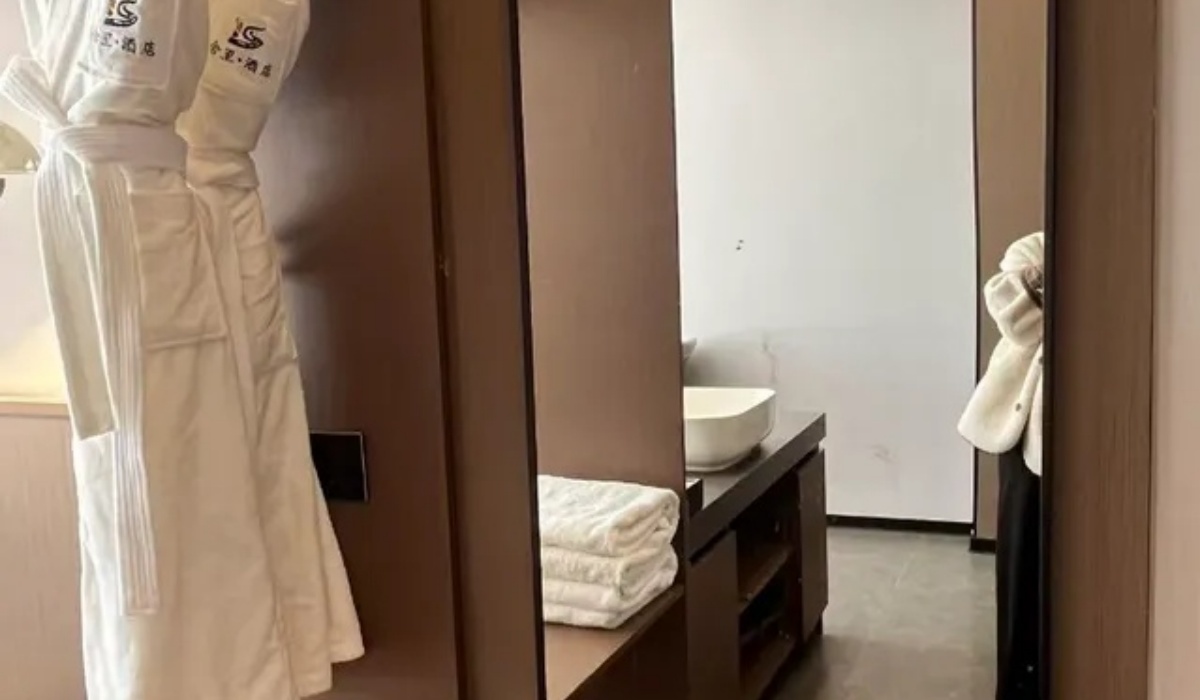 Plush white bathrobes and vanity area at Western Inn Sheli Hotel