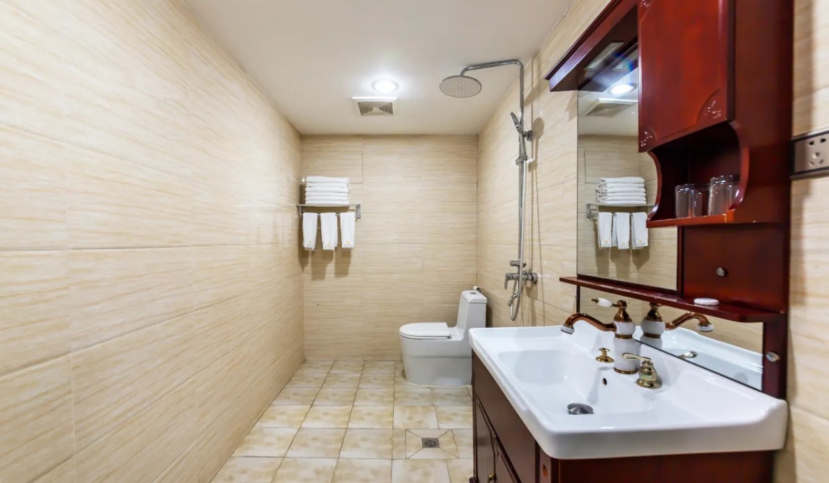 Clean hotel guest room bathroom with shower vanity and toilet