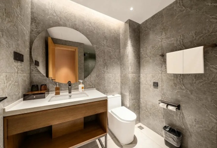 Modern hotel bathroom with marble walls, vanity, and toilet at QoMoLangZong Hotel Kayrung