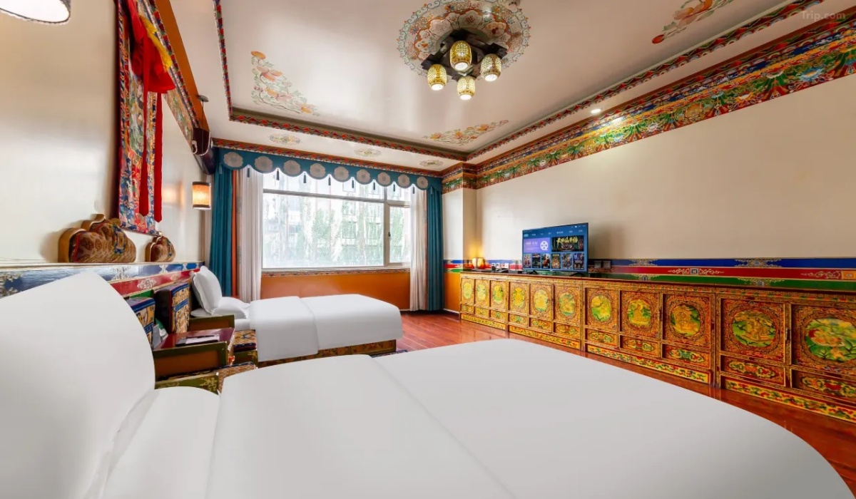 Tibetan style twin room with carved wooden cabinets and TV