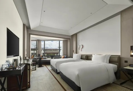 Deluxe twin room with double beds and a city view window at Hilton Shigatse