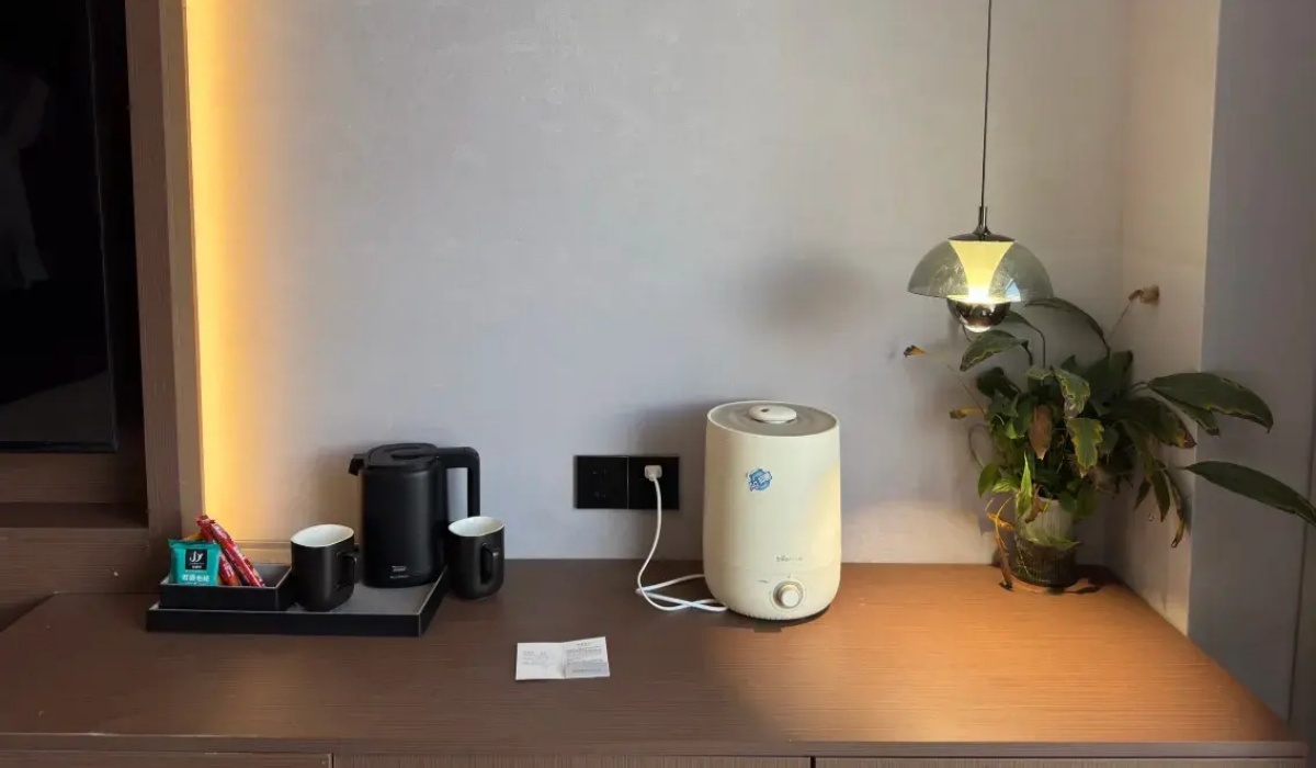 In-room humidifier and tea set on wooden desk at Western Inn Sheli Hotel