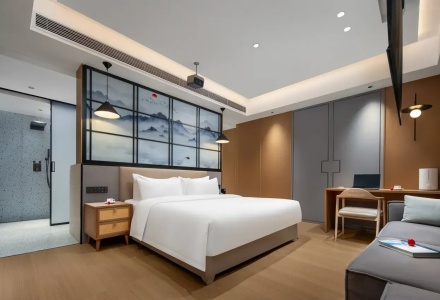 Modern king bedroom with work desk and sofa at Mullenlazone Shigatse Hotel