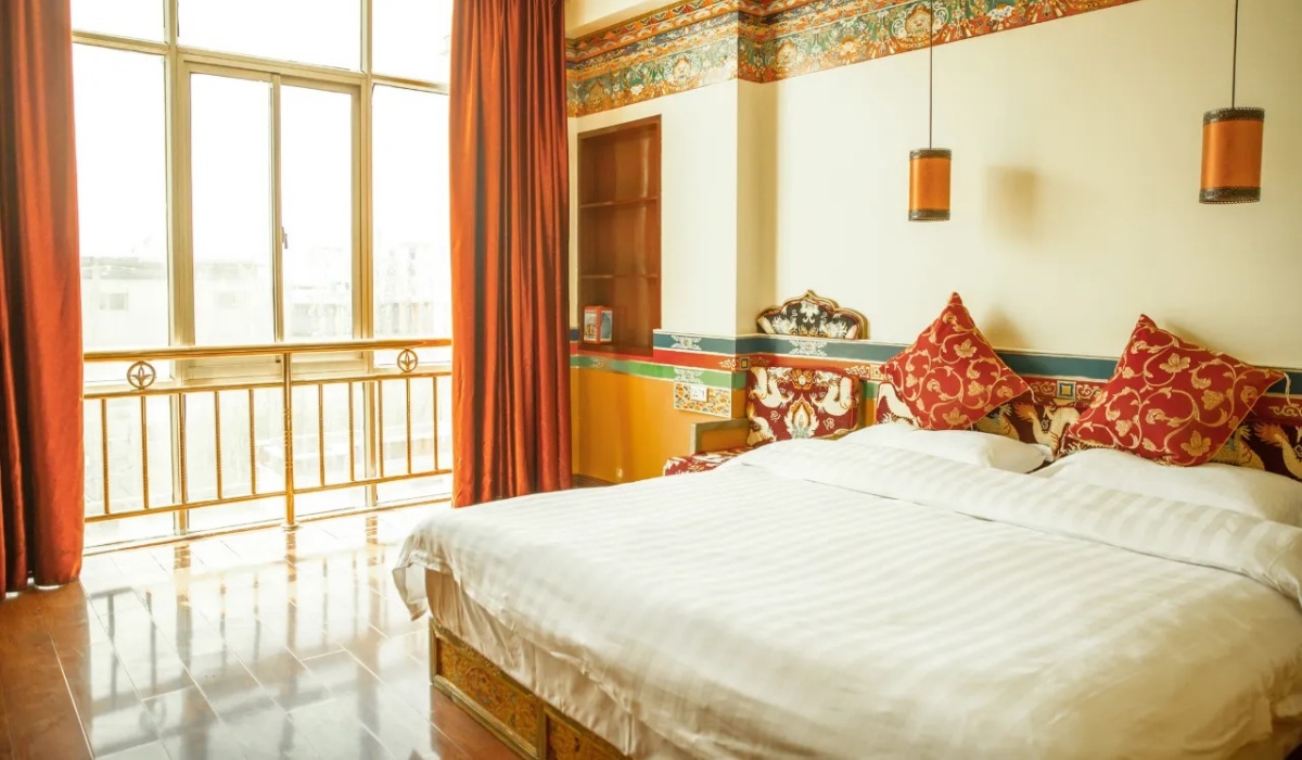 Bright guest room with large window and Tibetan bed decor