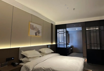 Cozy king bedroom with modern screen partition at Western Inn Sheli Hotel