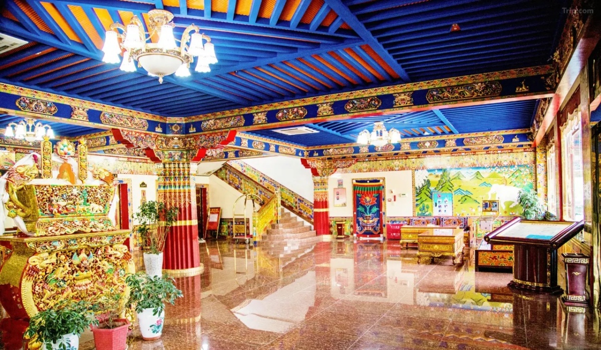 Grand lobby with decorated Tibetan pillars and staircase at Gesar Hotel