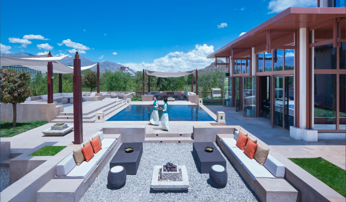 Outdoor seating area with a pond in Shangri-La Lhasa Hotel
