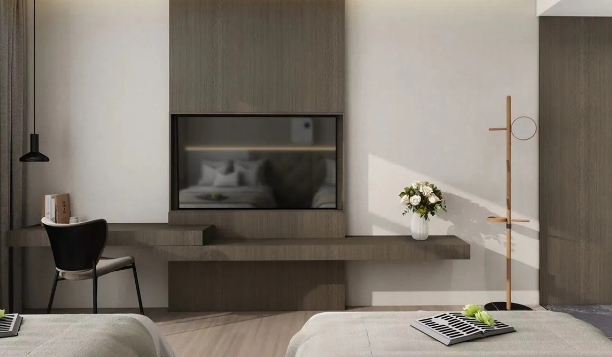 Wall-mounted TV setup and writing desk at Western Inn Sheli Hotel