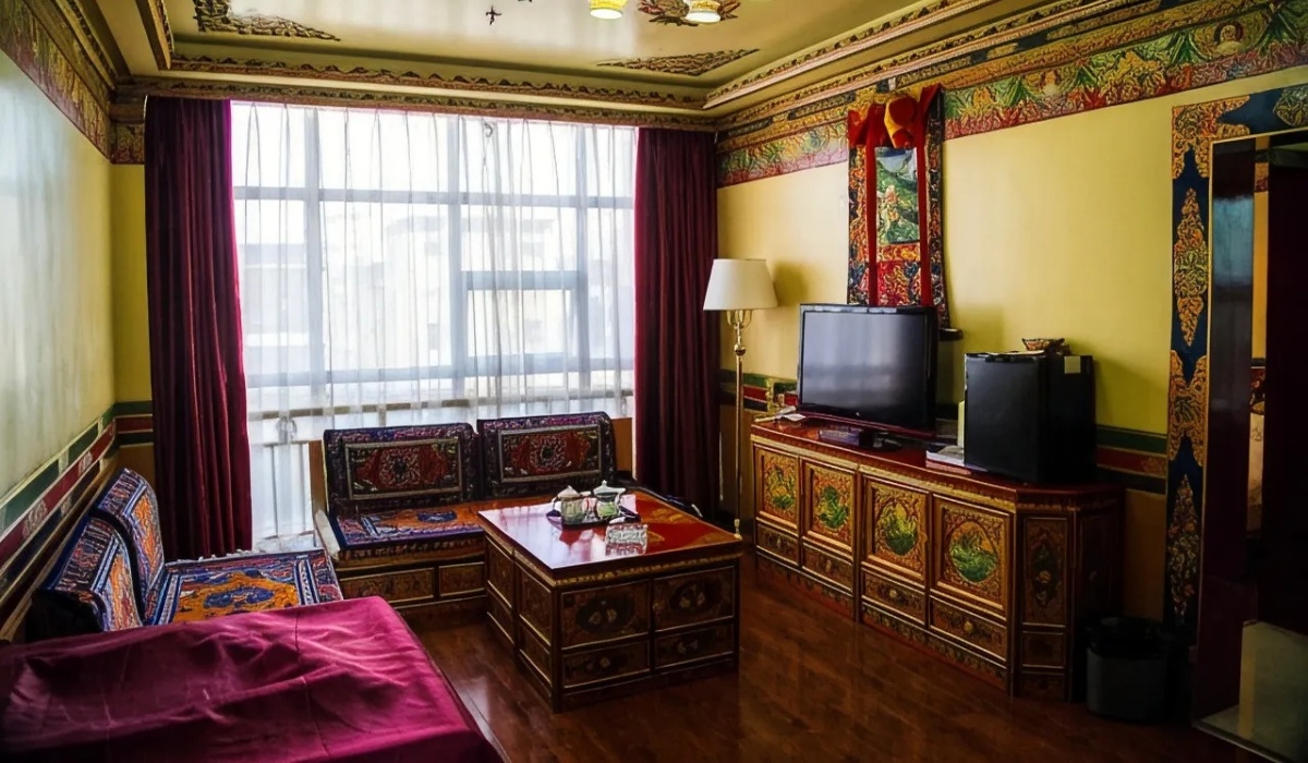Guest room sitting area with TV cabinet and traditional Tibetan sofa