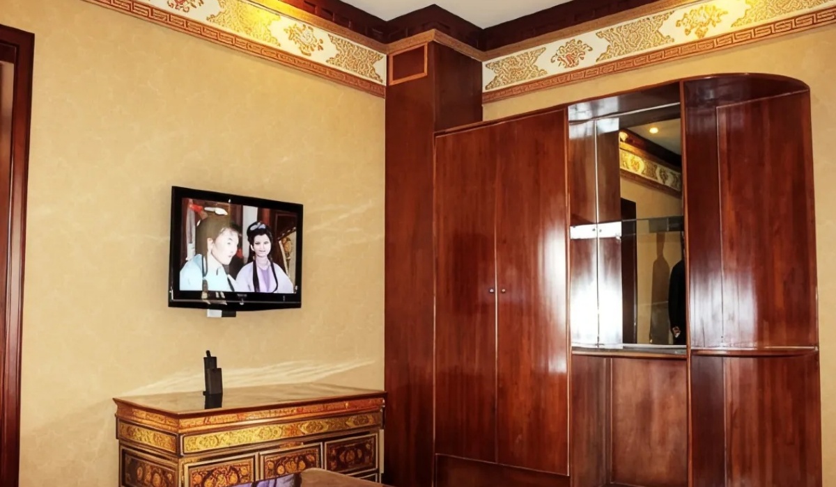 Wooden cabinet and wall mounted TV in guest room