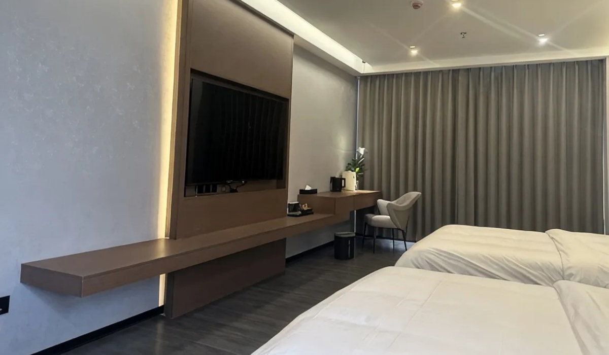 Guest room TV wall and comfortable bed at Western Inn Sheli Hotel