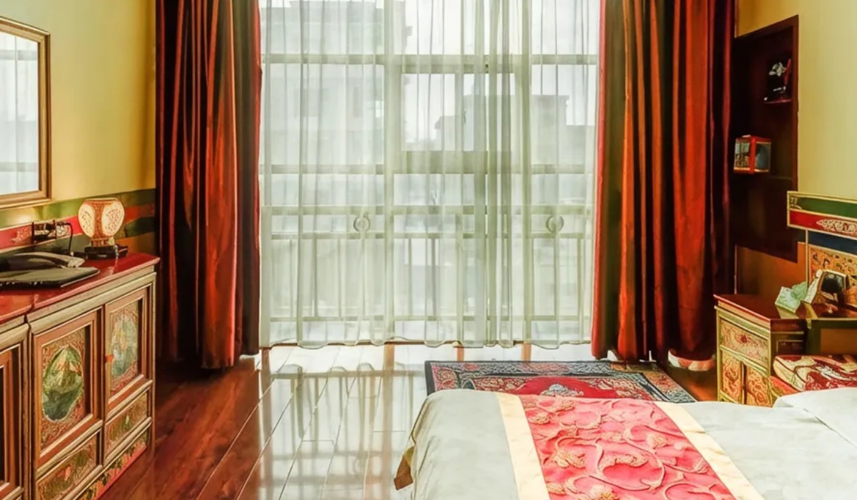 Guest room interior with large window red curtains and wooden cabinet