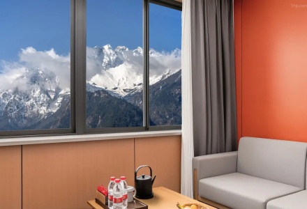 Cozy guest room sofa seating with snowy mountain window view at QoMoLangZong Hotel Kayrung