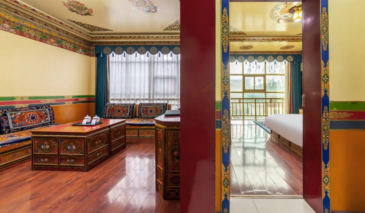 Hotel suite living room with Tibetan sofas and view into the bedroom