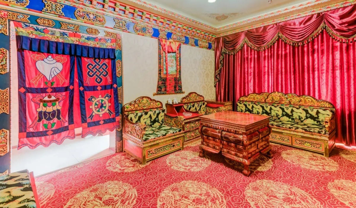 Traditional Tibetan lounge area with red curtains and carved sofas