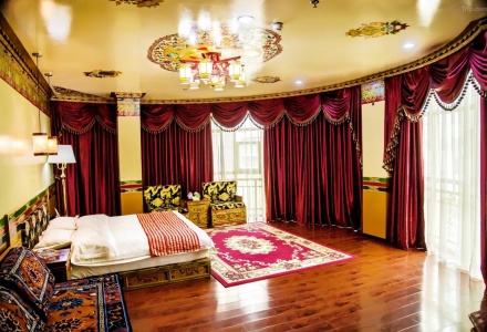 Spacious Tibetan style suite with large bed and red curtains