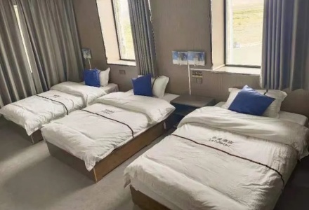 Spacious triple bedroom with three single beds at Letu Hotel Darchen