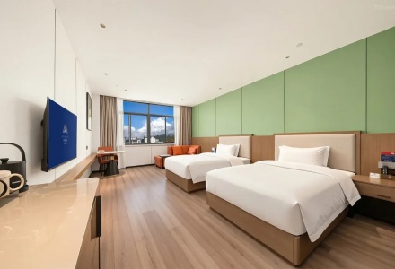 Spacious deluxe twin bed guest room with TV and seating area at QoMoLangZong Hotel Kayrung