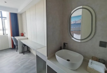 Clean bathroom vanity sink and writing desk in guest room at Shenling Mountain Hotel