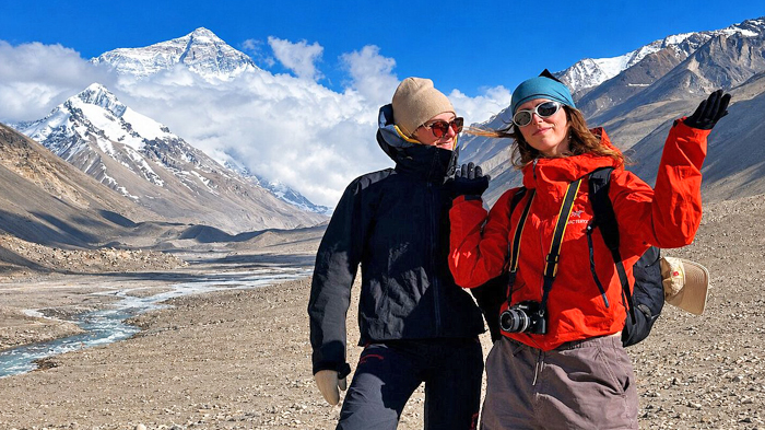 striking red fleece jackets posing in front of majestic Mount Everest