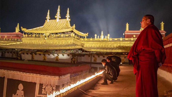 Tibetans are lighting butter lamps on the roof of Jokhang Temple
