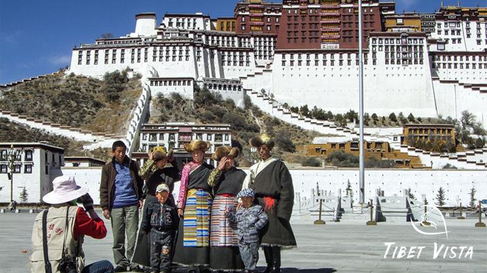 A Tibetan man dressed in Tibetan traditional dress took photos with his family