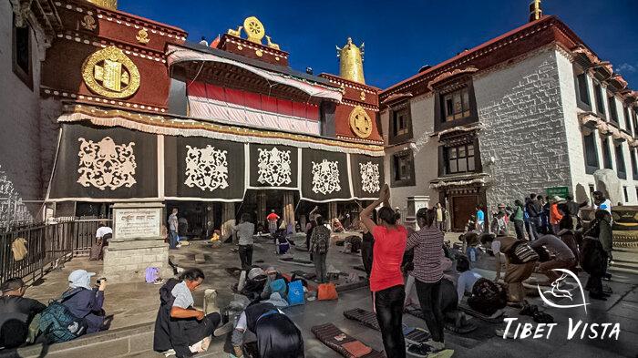 Tibet pilgrims prostrating themselves before the entrance of the Jokhang Temple