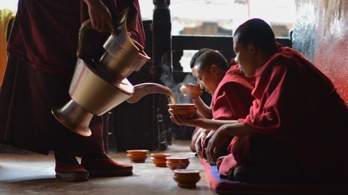 Tibetan monks enjoying yak butter tea
