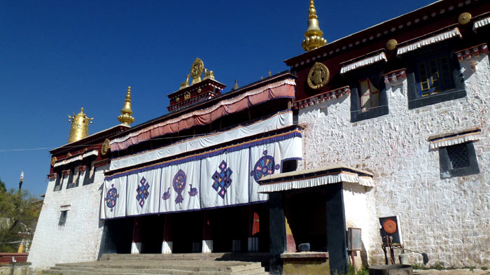 The Main Hall of Ganden Monastery - The Tsochin Hall with white walls and gilded roofs