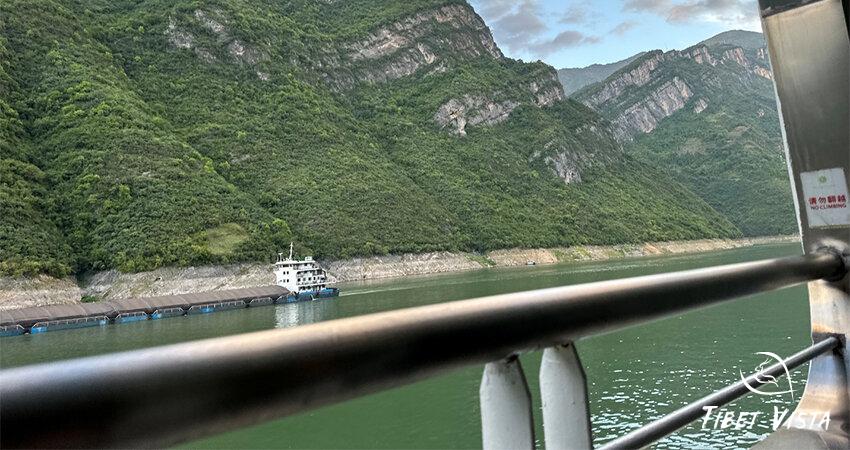 A scenic cruise on the Yangtze River with towering cliffs and mist-covered mountains