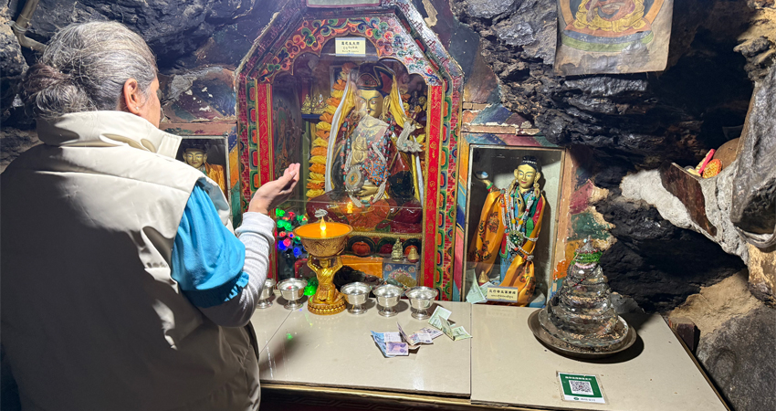 Tourist praying at Guru Rinpoche meditation cave