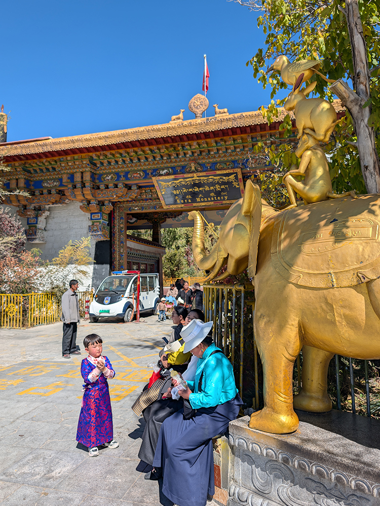 Local Tibetan families in traditional dress outside Sera Monastery