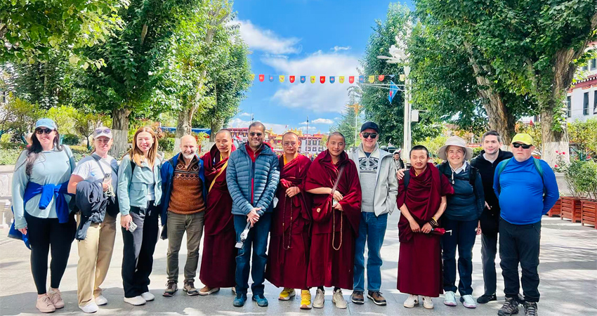 Group photo of tourists and local Tibetan monks in Lhasa, Tibet