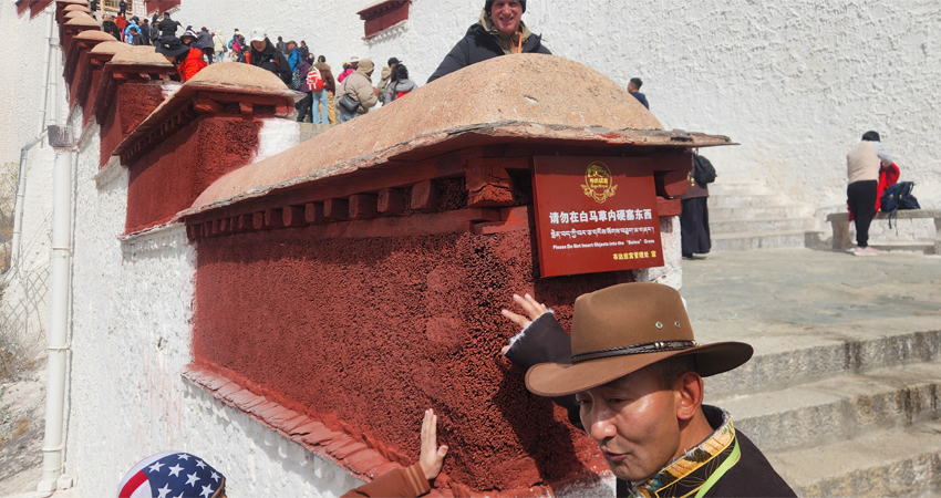 Guide showing details of Potala Palace to tourists