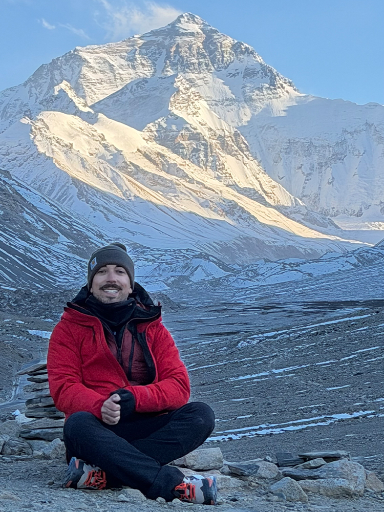 Traveler sitting at Tibet Everest Base Camp with Mount Everest