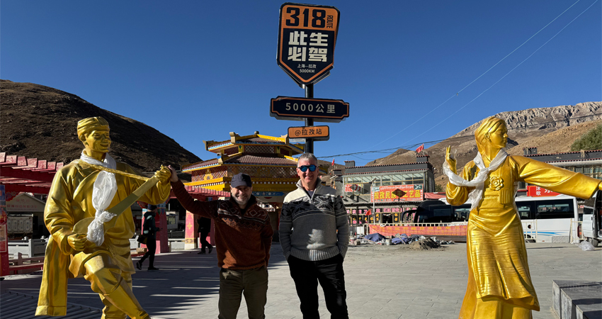 two men with golden statues on Tibet highway