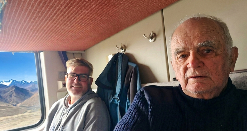Passengers in soft sleeper berth on Tibet train with mountain view