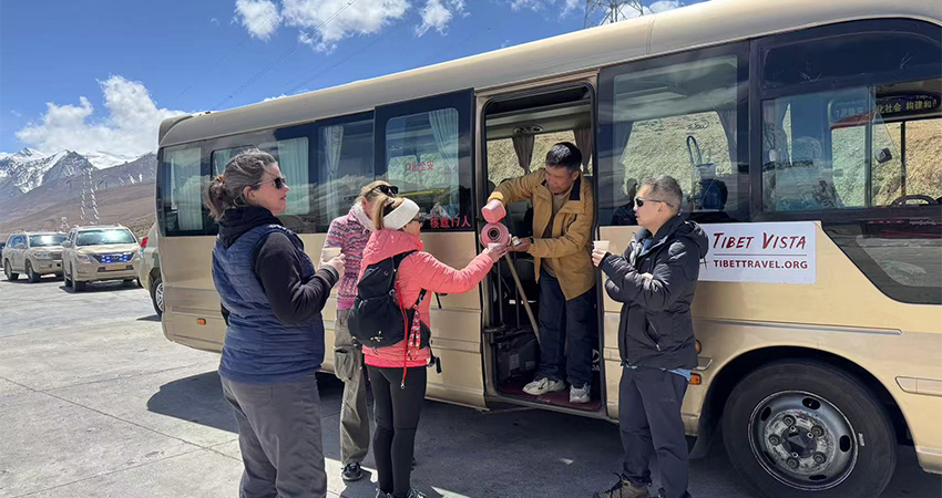 Tourists enjoying Tibetan tea during a road trip in Tibet